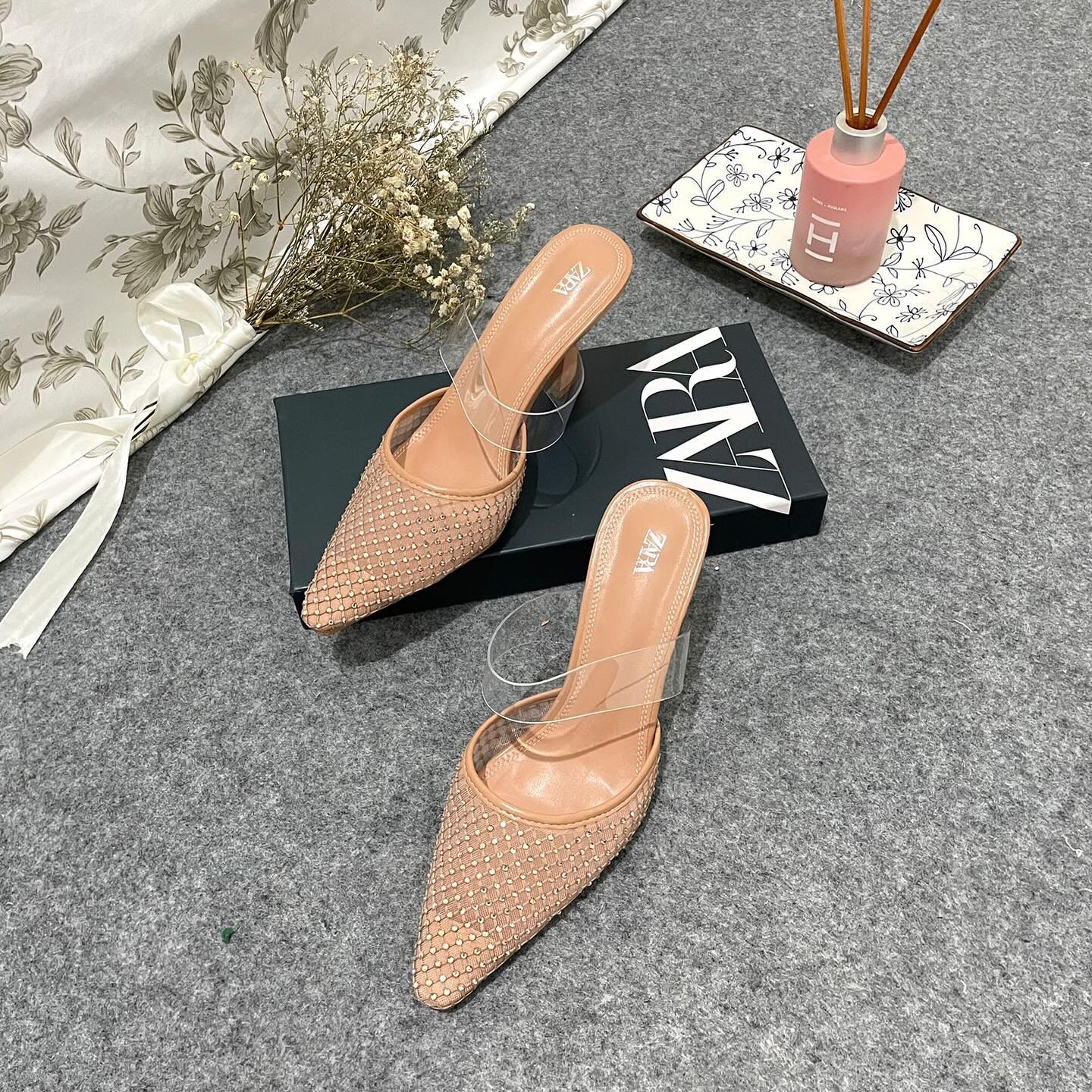 Mesh high-heel mules. Vinyl strap across the instep. Pointed toe